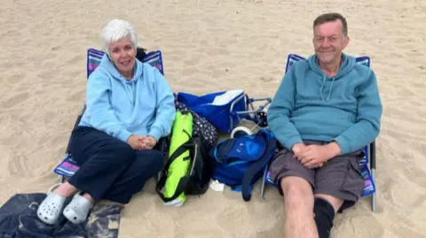 Andrea and Andrew McConnell sat on the beach